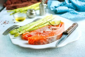 raw salmon and green asparagus on plate